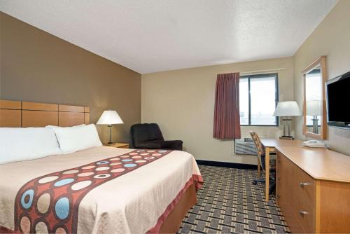 a hotel room with a bed and a desk at Super 8 by Wyndham Melrose in Melrose