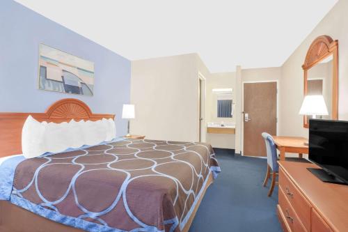 a hotel room with a bed and a flat screen tv at Super 8 by Wyndham Middletown in Middletown