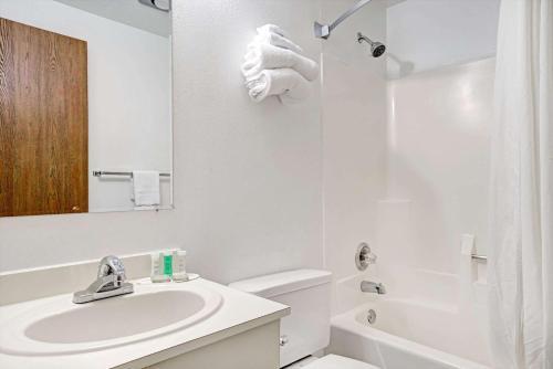 a white bathroom with a sink and a shower at Super 8 by Wyndham Chaska in Chaska