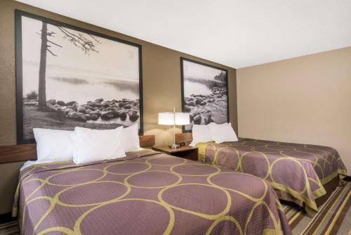 a hotel room with two beds and a picture on the wall at Super 8 by Wyndham St. Cloud in Saint Cloud