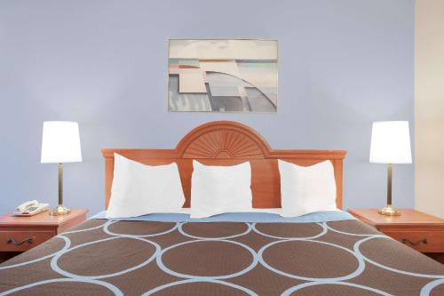 a bedroom with a bed with pillows and two lamps at Super 8 by Wyndham Middletown in Middletown