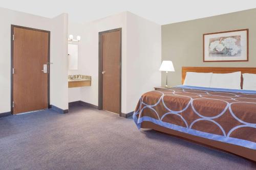 a hotel room with a bed and two doors at Super 8 by Wyndham Middletown in Middletown