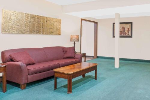 a living room with a purple couch and a coffee table at Super 8 by Wyndham Middletown in Middletown