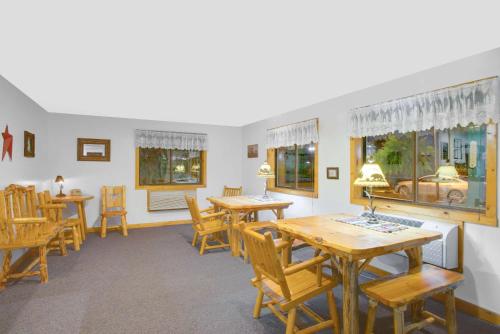 ein Esszimmer mit Tischen und Stühlen und Fenstern in der Unterkunft Super 8 by Wyndham Lake George/Warrensburg Area in Warrensburg