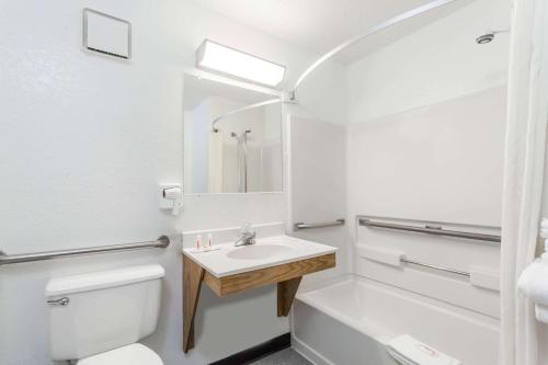 Baño blanco con lavabo y aseo en Super 8 by Wyndham Norwich, en Norwich
