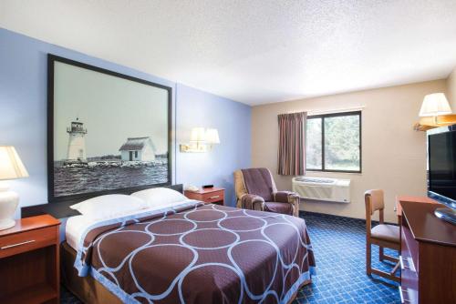 ein Hotelzimmer mit einem Bett und einem TV in der Unterkunft Super 8 by Wyndham Massena NY in Massena