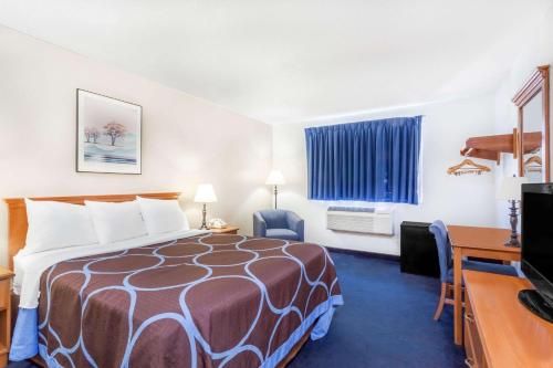 a hotel room with a bed and a desk at Super 8 by Wyndham Montgomery Maybrook in Montgomery