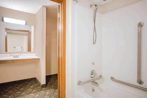 een badkamer met een douche en een wastafel bij Super 8 by Wyndham Monroe WI in Monroe