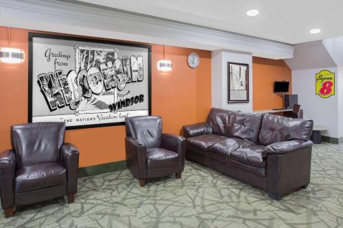 a waiting room with two leather chairs and a couch at Super 8 by Wyndham Windsor/Madison North in Windsor