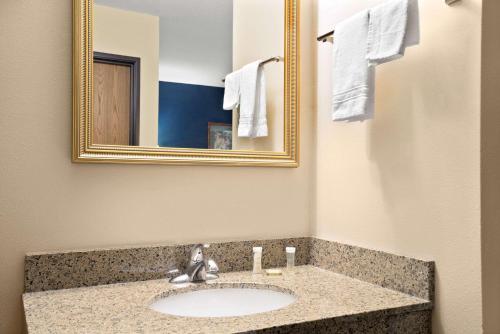 a bathroom with a sink and a mirror and towels at Super 8 by Wyndham Hudson in Hudson