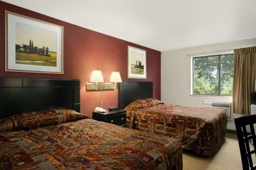 una camera d'albergo con due letti e una finestra di Super 8 by Wyndham New Castle a New Castle