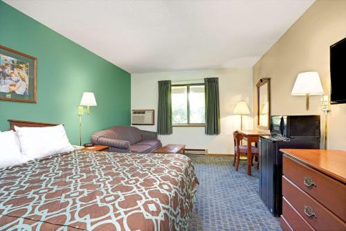 a hotel room with a bed and a television at Super 8 by Wyndham Hudson in Hudson