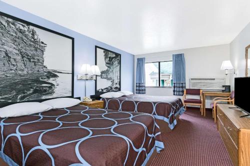a hotel room with two beds and a television at Super 8 by Wyndham Wisconsin Dells in Wisconsin Dells