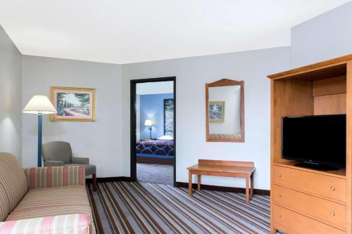 a hotel room with a bed and a flat screen tv at Super 8 by Wyndham Wisconsin Dells in Wisconsin Dells