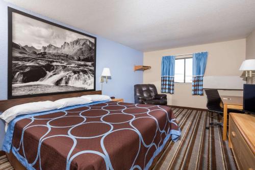 a hotel room with a bed and a desk at Grizzly Inn in Great Falls