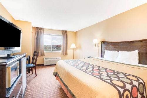 a hotel room with a bed and a flat screen tv at Super 8 by Wyndham Kutztown/Allentown Area in Kutztown