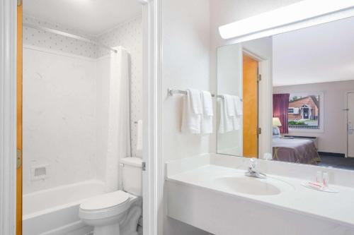 uma casa de banho com um lavatório, um WC e um espelho. em Super 8 by Wyndham Christiansburg em Christiansburg