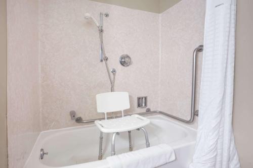 a white bath tub with a chair in a bathroom at Grizzly Inn in Great Falls