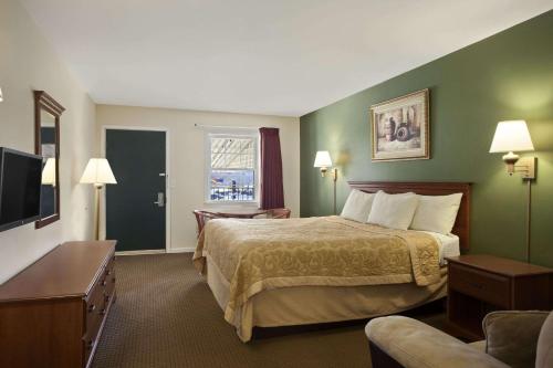 a hotel room with a bed and a television at Super 8 by Wyndham Mifflinville Near Bloomsburg in Mifflinville