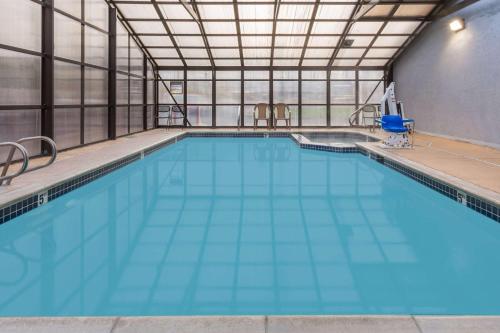a large swimming pool with blue water at Super 8 by Wyndham Logan in Logan