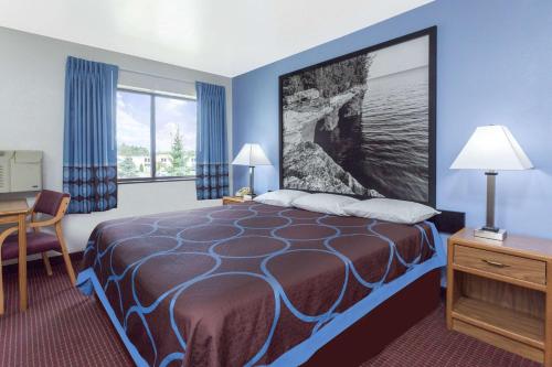a hotel room with a bed and a window at Super 8 by Wyndham Wisconsin Dells in Wisconsin Dells
