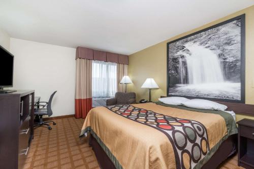a hotel room with a bed and a tv at Super 8 by Wyndham Rice Lake in Rice Lake