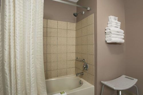 a bathroom with a tub and a shower curtain at Super 8 by Wyndham New Castle in New Castle