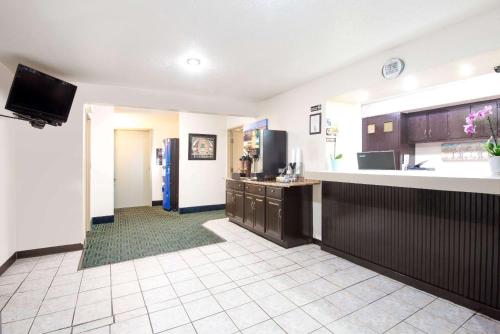 a large kitchen with a counter and a refrigerator at Super 8 by Wyndham Pittsburgh PA Airport-University Area in Moon Township