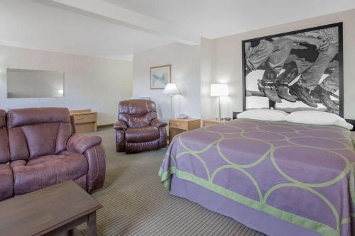 Pokój hotelowy z łóżkiem i krzesłem w obiekcie Super 8 by Wyndham Havre w Hawrze