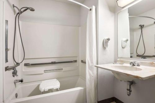a white bathroom with a tub and a sink at Brookville Inn in Brookville