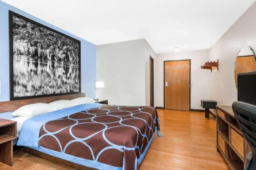a hotel room with a bed and a flat screen tv at Super 8 by Wyndham Oneonta/Cooperstown in Oneonta