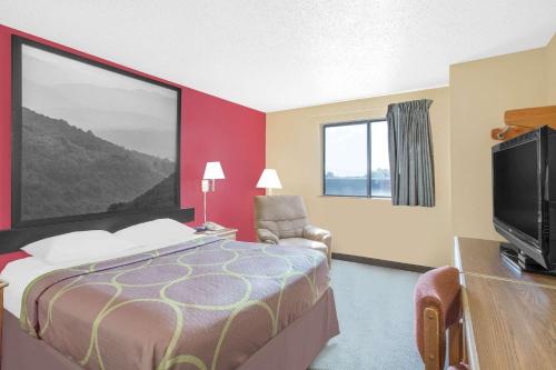 a hotel room with a bed and a flat screen tv at Super 8 by Wyndham Roanoke VA in Roanoke