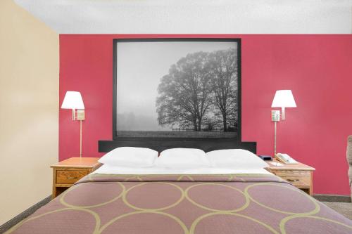 a bedroom with a red wall with a bed and a tree at Super 8 by Wyndham Roanoke VA in Roanoke