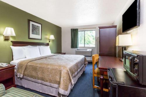 a hotel room with a bed and a television at Super 8 by Wyndham Hampton in Hampton