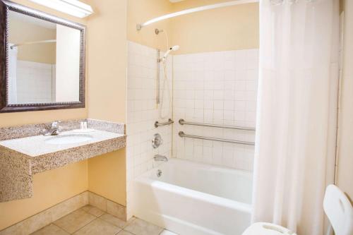 a bathroom with a tub and a sink and a shower at Super 8 by Wyndham Harrisonburg in Harrisonburg
