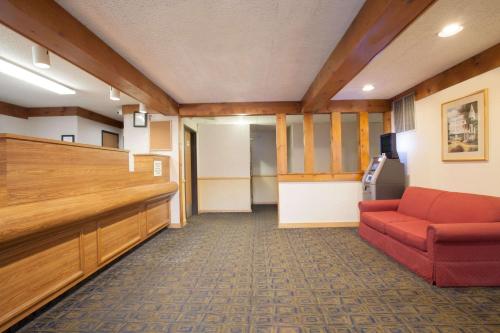 a waiting room with a red couch in a hospital at Super 8 by Wyndham Oneonta/Cooperstown in Oneonta