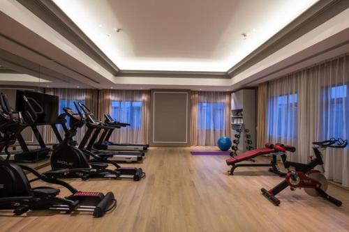 a gym with treadmills and exercise bikes in a room at Mercure Shanghai Jiuting in Shang-hai