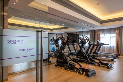 a gym with several cardio machines in a room at Mercure Shanghai Jiuting in Shang-hai