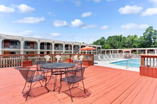 a patio with a table and chairs next to a pool at Super 8 by Wyndham Williamsburg/Historic Area in Williamsburg