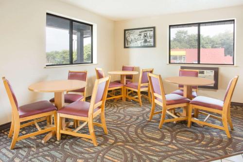 a waiting room with tables and chairs and windows at Super 8 by Wyndham Lexington VA in Lexington