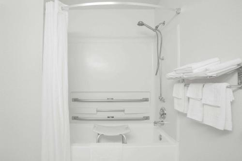 Baño blanco con espejo y toallas en Super 8 by Wyndham Appomattox VA, en Appomattox