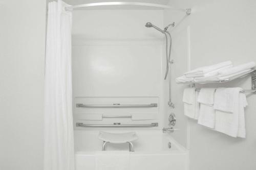 a white bathroom with a mirror and towels at Super 8 by Wyndham Appomattox VA in Appomattox