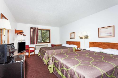 a hotel room with two beds and a flat screen tv at Super 8 by Wyndham Winchester VA in Winchester