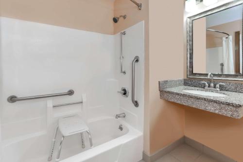 a bathroom with a tub and a sink and a mirror at Super 8 South by Wyndham in Bowling Green