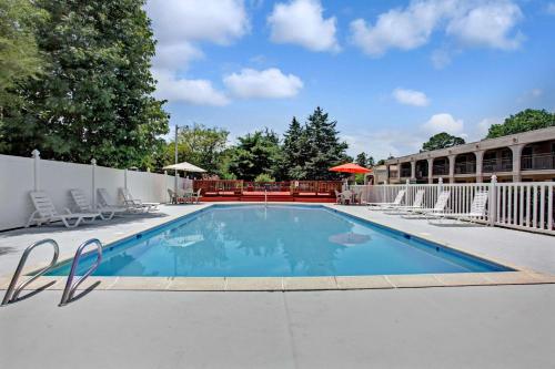 a swimming pool at a resort with chairs around it at Super 8 by Wyndham Williamsburg/Historic Area in Williamsburg