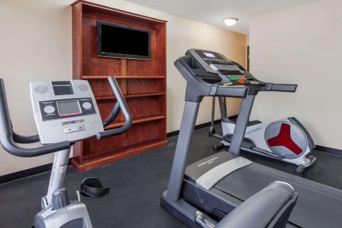 a room with a gym with a treadmill and a television at Super 8 South by Wyndham in Bowling Green