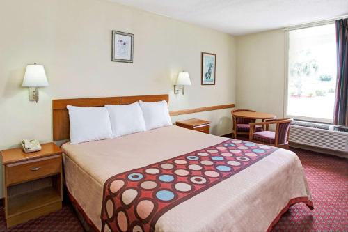 a hotel room with a large bed and a window at Super 8 by Wyndham Walterboro in Walterboro