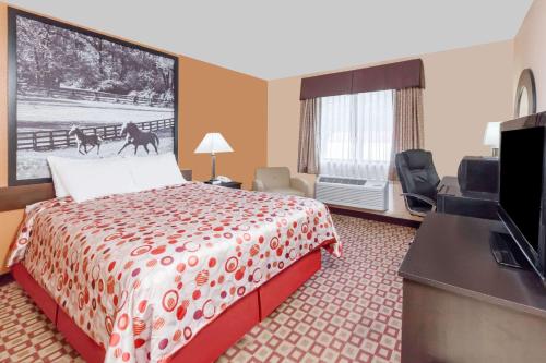 a hotel room with a bed and a flat screen tv at Super 8 South by Wyndham in Bowling Green