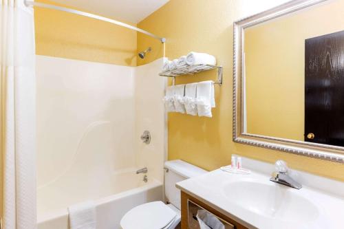 ein Badezimmer mit einem Waschbecken, einem WC und einem Spiegel in der Unterkunft Super 8 by Wyndham Richmond in Richmond