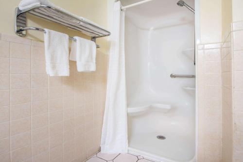 a bathroom with a shower with white towels at Super 8 by Wyndham Tulsa/Arpt/St Fairgrounds in Tulsa